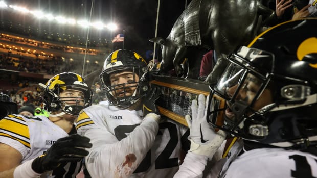 Nov 19, 2022; Minneapolis, Minnesota, USA; Iowa Hawkeyes players celebrate with the Floyd of Rosedale after defeating the Minnesota Golden Gophers at Huntington Bank Stadium. (Matt Krohn-USA TODAY Sports)